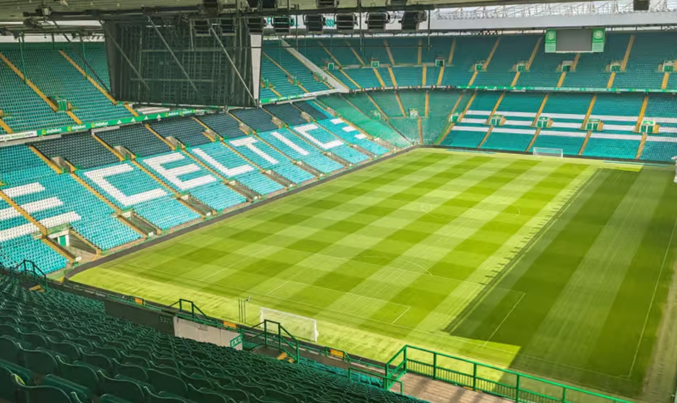 stadion sepak bola penuh penonton saat pertandingan malam hari dengan sorotan lampu stadion modern